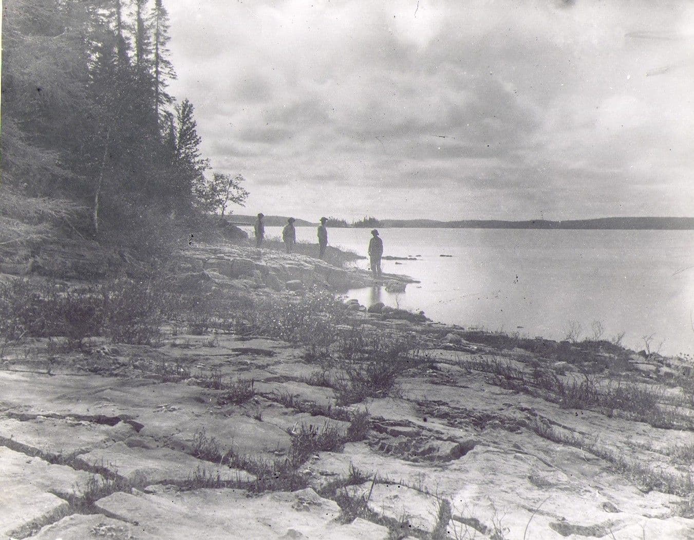 Quatre hommes dans la région du lac Mistassini, montrant à l’avant-plan des calcaires de l’ère précambrienne, vers 1892. 