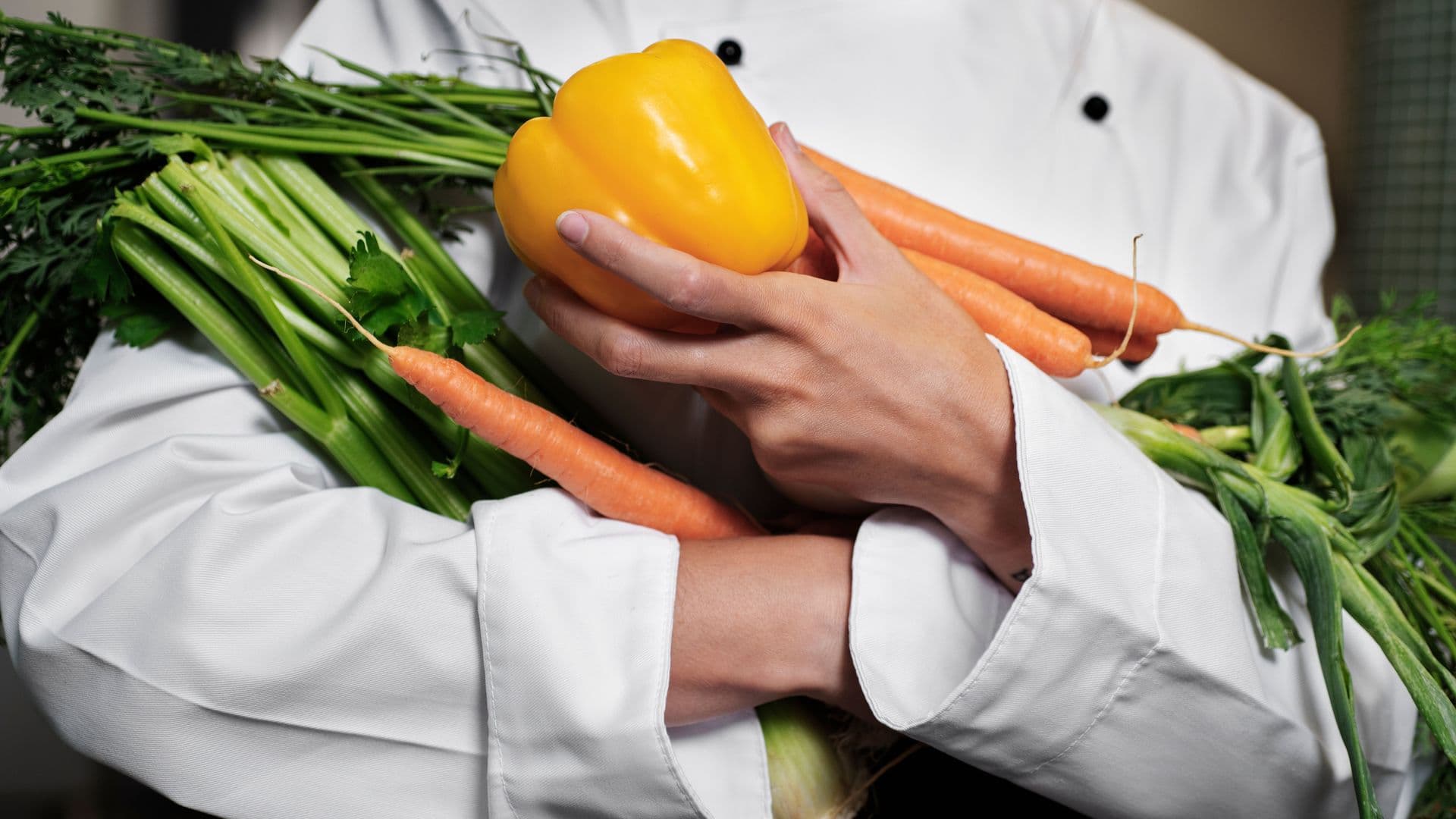 Chef féminin dans la cuisine tenant des légumes